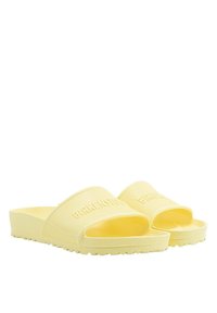 Chanclas amarillas de goma texturizada, con una banda ancha que presenta una marca en relieve. El diseño tiene una suela plana con un agarre estampado.