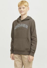 Felpa marrone con tasca frontale, cappuccio con cordino e testo del logo bianco. Tessuto morbido con polsini e orlo a coste, abbinata a pantaloni beige chiaro.