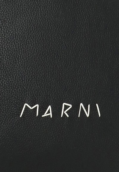 Superficie in pelle nera testurizzata con lettere bianche cucite che formano il nome del marchio "MARNI" al centro.