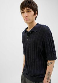 Polo shirt bleu marin cu mânecă scurtă, prezentând un model texturat de tricot cu cabluri, placket cu trei nasturi și guler și tiv ribbed. Croială casual.