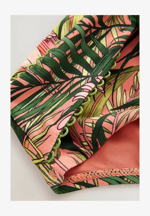 Floral print fabric featuring green leaves on a pink background, with green accent trim and textured stitching details along the edges.