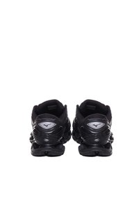 Scarpe da ginnastica nere con un design testurizzato, dotate di una suola a forma di onda distintiva e dettagli riflettenti sul tallone e sul logo.