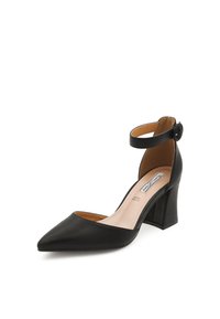 Scarpa alta in pelle nera con punta affusolata e cinturino alla caviglia. Caratterizzata da un tacco spesso e una finitura liscia. Parte superiore e fodera visibili.