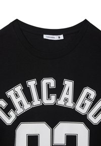 Maglietta nera con "CHICAGO 92" in lettere bianche in grassetto. Presenta un collo rotondo e una morbida texture di cotone. Etichetta del marchio: Terranova, taglia S.