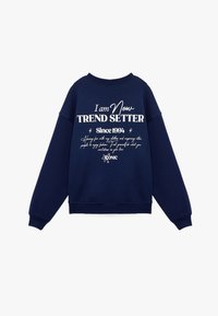 Sudadera azul marino de mezcla de algodón, con el texto blanco "Soy el MARCADOR DE TENDENCIAS Desde 1994" acompañado de elementos decorativos y un cuello redondo.