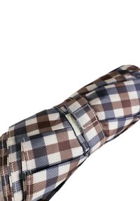 Tessuto a quadri marrone e blu, con quadrati alternati di texture liscia e design sartoriale, include un dettaglio con tasca laterale.