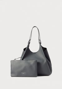 Sac fourre-tout en cuir gris foncé avec une texture lisse et une large ouverture arrondie. Comprend une pochette zippée assortie avec un logo discret.