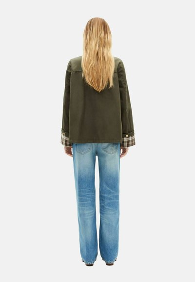 Chaqueta verde oliva con mangas anchas y acentos a cuadros, combinada con jeans azul claro de pierna recta. Vista trasera, textura suave, estilo casual.