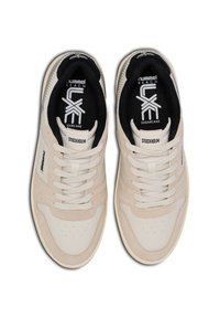 Tenis bege com detalhes em couro liso e têxtil, apresentando um bico arredondado, perfurações, atacadores planos e logótipo na língua.