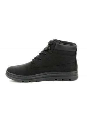 Botas altas negras de ante y material sintético. Cuentan con cordones, puntera redonda, cuello acolchado y suela de goma texturizada.