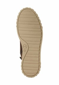 Semelle de chaussure marron avec un bord ondulé et une texture striée. Présente un logo circulaire et une fermeture éclair sur le côté pour un accès facile. Fabriquée en matériau en caoutchouc.
