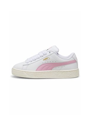 Biały niski sneaker Puma z różowym paskiem, złotym logo, wyściełanym kołnierzem i fakturowaną, kremowo-białą gumową podeszwą, pokazany z profilu.