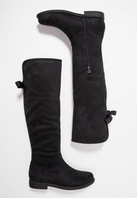 Czarne, wysokie za kolano botki wykonane z miękkiego zamszu, z gładkim wykończeniem, bocznym zamkiem błyskawicznym i małymi wstążkami u góry. Niska, płaska podeszwa.