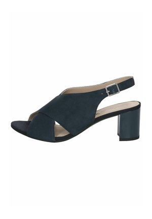 Sort ruskind åben tå slingback sandal med krydsede remme, sølvspænde og blokhæl på hvid baggrund.