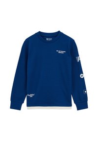 Modra dolga majica s kapuco iz teksturirane tkanine. Ima tiskane logotipe, rebraste manšete in bel dodatek na robu.