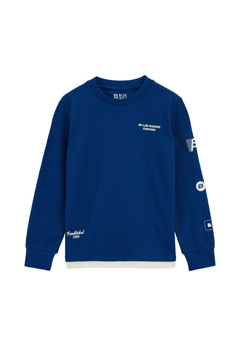 Modra dolga majica s kapuco iz teksturirane tkanine. Ima tiskane logotipe, rebraste manšete in bel dodatek na robu.