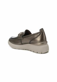 Zapatos de cuero bronce sin cordones con punta redonda, costuras sutiles y una gruesa suela de goma beige. Presentan una hebilla decorativa.