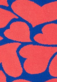 Strickstoff mit einem sich wiederholenden Herzmuster in Blau auf einem Korallenhintergrund. Die Herzen sind umrandet und verleihen ein strukturiertes Erscheinungsbild.