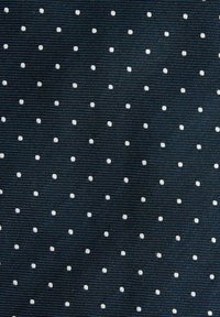 Donkere stof met een ribbelstructuur waarin kleine witte stippen gelijkmatig over het oppervlak verspreid zijn.