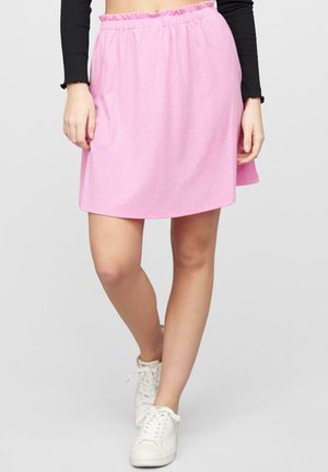 Rosa, knelange skjørt med samlet elastisk liv, med et subtilt teksturert mønster. Kombinert med hvite sneakers.