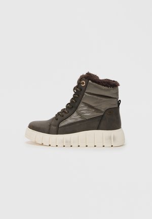 Sneaker alte marroni con colletto in ecopelliccia, pannelli lucidi e suola bianca spessa. Presentano dettagli in bronzo e un design imbottito per il comfort.