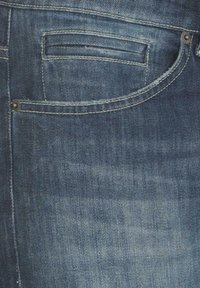 Blå denimjeans med en bakficka med rund form, enkel horisontell söm och metalldekorativnail. Subtila texturer och blekningar.