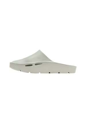 Zueco sin cordones de color gris claro con suela gruesa y dos pequeños orificios de ventilación en el lateral.