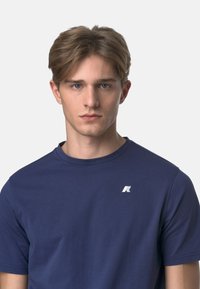 T-shirt blu navy realizzato in tessuto morbido, con scollatura rotonda e un piccolo logo bianco sulla parte sinistra del petto. Maniche corte.