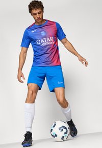 Blå Nike trøje med gradient fra blå til rød, med "Qatar Airways" logo. Blå shorts, hvide knæ-høje sokker og sorte fodboldstøvler.