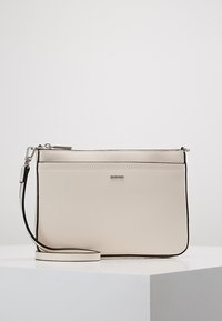 Beige crossbody taška vyrobená z texturovaného syntetického materiálu se stříbrným zipovým uzávěrem a kontrastní černou obšívkou. Obsahuje odnímatelný popruh.