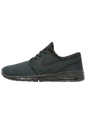 Baskets de sport en mesh noir avec une tige texturée, dotées d'un col rembourré, de lacets noirs et d'un amorti aérien visible dans la semelle.