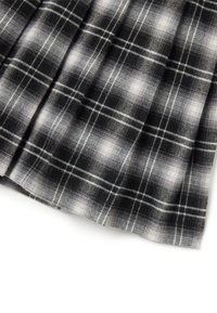 Tessuto a scacchi in bianco e nero con una consistenza morbida, caratterizzato da un motivo di linee e quadrati che si intrecciano, con dettagli plissettati su un bordo.