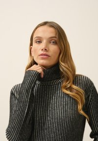 Czarny i szary sweter z golfem w paski, z długimi rękawami, charakteryzujący się ribbowanym wykończeniem i wysokim dekoltem, zapewniający dopasowane dopasowanie.