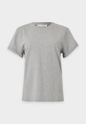Femme debout portant un t-shirt gris clair à manches courtes, un pantalon large taille haute noir avec ceinture et des talons pointus noirs.