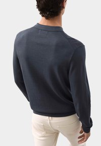 Donkerblauwe pullover trui voor heren met een kraag, geribde manchetten en zoom. Glad textuur met subtiele details op de schoudernaden.
