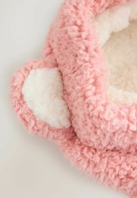 Rosa, flauschige Tierliege mit einer weichen, strukturierten Außenseite und einem weißen, plüschigen Innenfutter. Verfügt über abgerundete Ohren und ein gemütliches Design.
