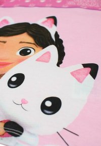 Impression graphique représentant un personnage aux cheveux foncés et un chat blanc avec des accents roses, sur un fond rose clair.