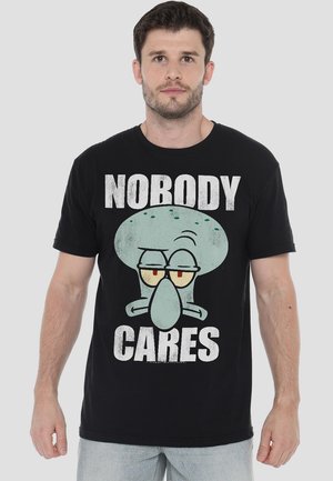 Black cotton t-shirt featuring a graphic print of a cartoon character with the text "NOBODY CARES" in bold white letters.