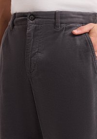 Gray cotton trousers featuring a smooth texture, button closure, and side pockets, with a fitted design and subtle diagonal pattern.