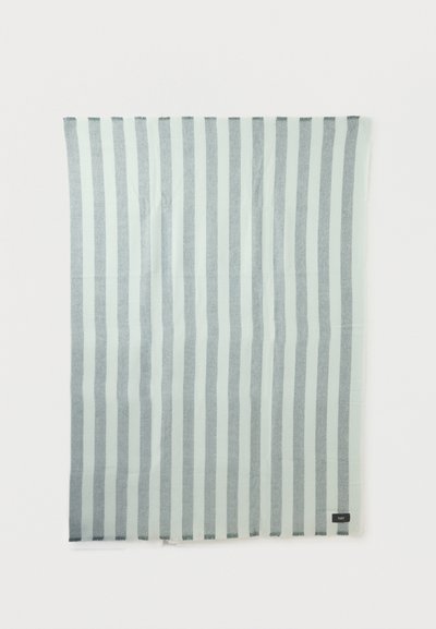 Ορθογώνιο ύφασμα με ανοιχτό μπλε και γκρι ρίγες και μικρό μαύρο ετικέτα με την επιγραφή «HAY» στην κάτω δεξιά γωνία.