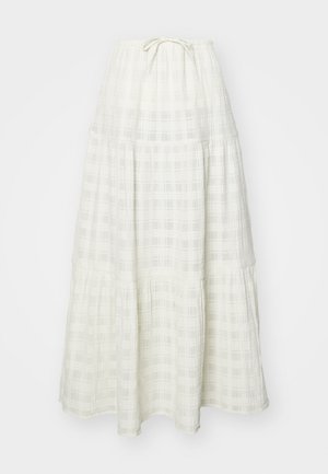 Long white skirt made of textured fabric, featuring a checkered pattern, tiered design, and a tapered tie at the waist.