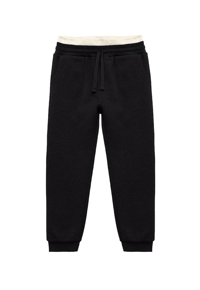 Zwarte joggingsbroek van een gestructureerde stof, met een witte trekceintuur bij de taille en elastische boorden; bevat zijzakken.