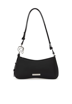 Sort skuldertaske med buet bund, justerbar rem, metal logo-plakette og sølvvedhæng formet som et ansigt med solbriller.