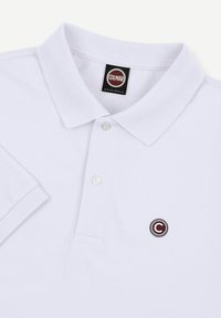 Weißes kurzärmeliges Poloshirt mit Kragen, zwei Knöpfen und einem runden "C"-Logo auf der linken Brust unter dem Label "Colmar Originals".