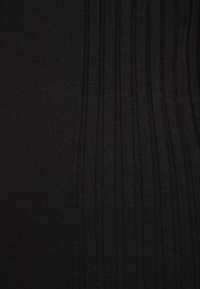 Textile noir présentant une texture côtelée verticale avec une profondeur subtile, mettant l'accent sur les lignes et le matériau lisse. Aucuns motifs ou éléments matériels notables.