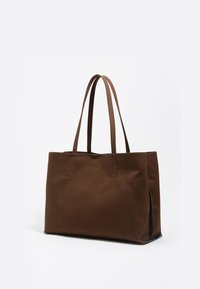 Ruda rankinė su dviem rankenomis, pagaminta iš lygaus audinio. Stačiakampio formos, minimalizmo siuvimo detalės ir atviras viršus.