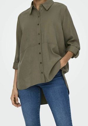 Camisa de botón verde oliva con cuello, aberturas laterales y mangas enrolladas; fabricada en un tejido suave con textura lisa.