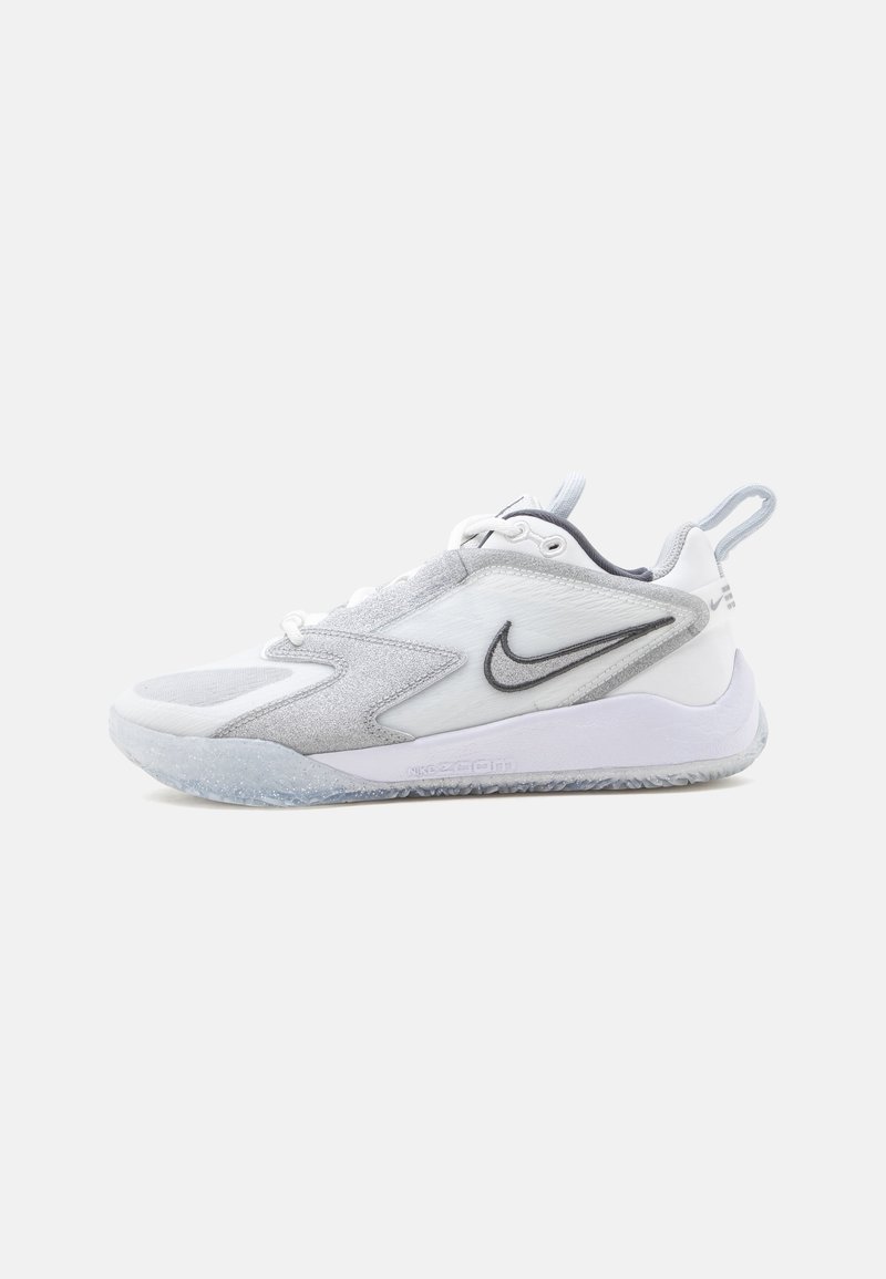 Chaussure de sport Nike blanche et grise avec logo swoosh noir, design à lacets, languette au talon et semelle translucide texturée.