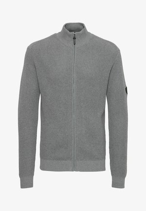 Grå strikket cardigan med høy krage, hel frontglidelås, teksturert stoff, ribbestrikkede mansjetter og sidepatch-detalj.