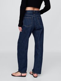 Dunkelblaue Denim-Bootcut-Jeans mit hoher Taille, die ein klassisches Fünf-Taschen-Design und sichtbare Nähte an den Säumen aufweisen.